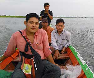 Volunteers Ko Htet Aung and La Rein from Joining Hands and Ko Si Thu from Lands in Our Hands (Do Myay Hkun Yet) on the swollen Ayeyarawady River